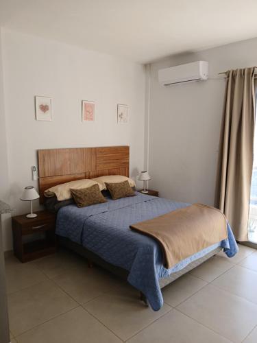 a bedroom with a blue bed with two pillows at Dpto en Costanera, excelente ubicación in Corrientes