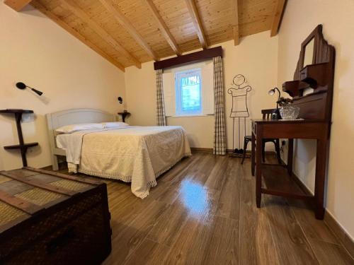 a bedroom with a bed and a table and a window at Eido de Bairros - Casa Vinha da Touça T1 in Soajo