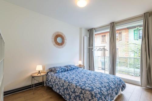 ein Schlafzimmer mit einem Bett und einem großen Fenster in der Unterkunft M001 Marquer Agréable T2 centre ville in Annemasse