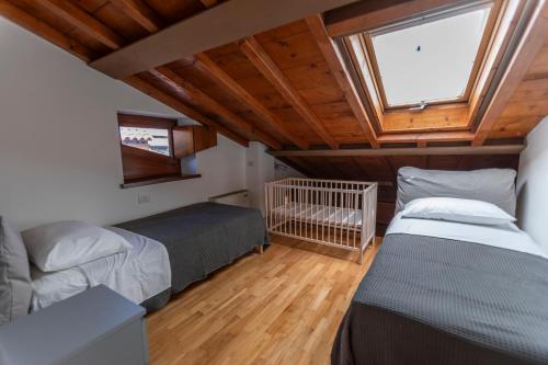 Un dormitorio con dos camas y una ventana. en Giardino Giusti Home, en Verona
