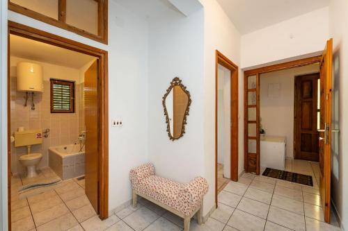 baño con silla y espejo en la pared en Dodo Sea View Apartments, en Novalja