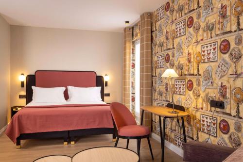 a bedroom with a bed and a wall with pictures at Hotel le 46 in Paris