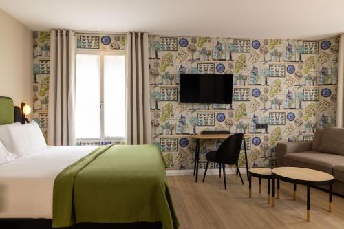 a hotel room with a bed and a couch and a tv at Hotel le 46 in Paris