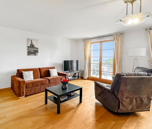 un salon avec un canapé et une table dans l'établissement Harmonie au Plessis-Robinson, au Plessis-Robinson