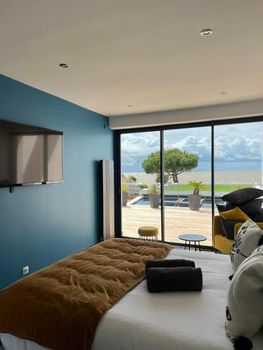 une chambre avec un grand lit et un mur bleu dans l'établissement Villa Angoulins front de mer, à Angoulins-sur-Mer