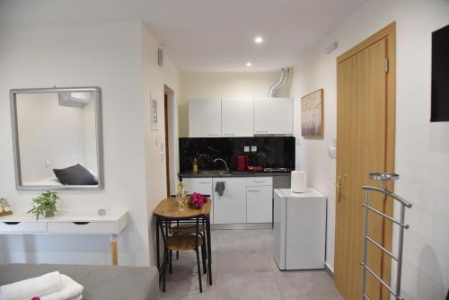 a kitchen with a small table and a white refrigerator at Aloha Inn in Artemida
