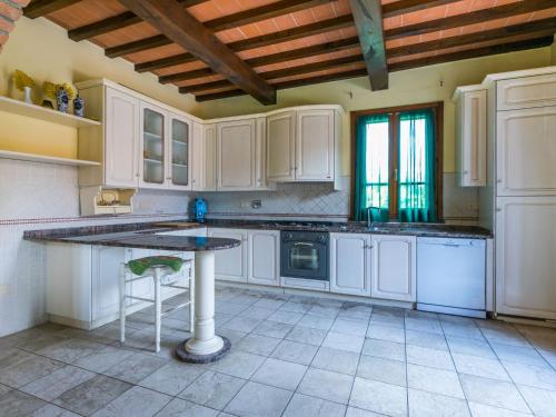 a large kitchen with white cabinets and a table at Villa Villa Elena-1 by Interhome in Le Vedute