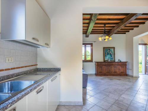 a kitchen with white cabinets and a tile floor at Villa Villa Elena-1 by Interhome in Le Vedute