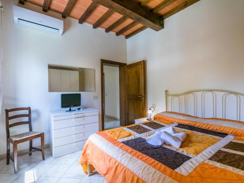 a bedroom with a bed and a chair and a television at Villa Villa Elena-1 by Interhome in Le Vedute