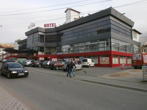 a man crossing the street in front of a hotel at Meka Hotel in Dragash