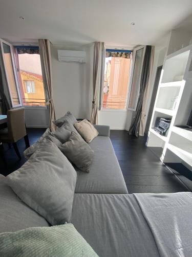 - un grand lit dans une pièce dotée de fenêtres dans l'établissement Agréable T2 rénové, Cannes centre, Suquet, plages, à Cannes