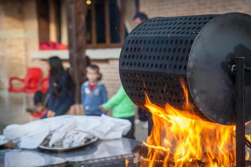 a grill over a fire with plates of food at Complejo Turístico Las Cañadas Casas de Campo- Actividades Gratuitas Todos los Fines de Semana in Baños de Montemayor