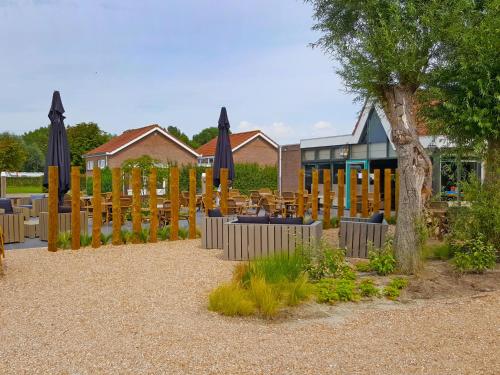 a patio with tables and umbrellas in front of a building at Holiday Home Long Beach by Interhome in Retranchement