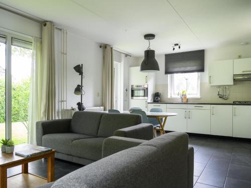 a living room with a couch and a table at Holiday Home Bungalowpark It Wiid by Interhome in Eernewoude