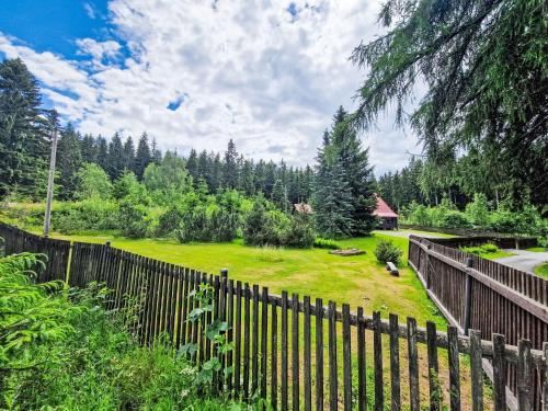 a fence in front of a yard with trees at Holiday Home Jelení kout by Interhome in Smržovka