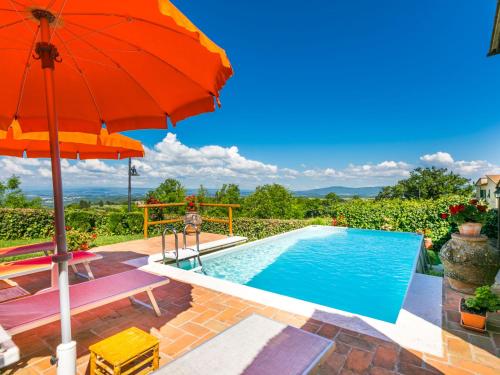 pomarańczowy parasol oraz basen z krzesłami i stołem oraz umbrellaoba w obiekcie Holiday Home Casa Alfredo by Interhome w mieście Castel San Gimignano