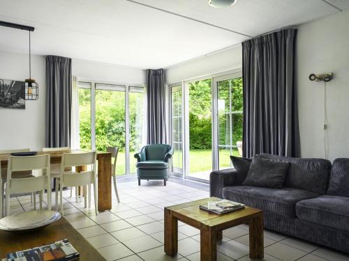 ein Wohnzimmer mit Sofa und Tisch in der Unterkunft Holiday Home Bungalowpark It Wiid by Interhome in Eernewoude