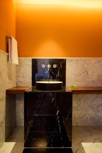a bathroom with a black counter with a sink at Hotel Luzeiros Fortaleza in Fortaleza