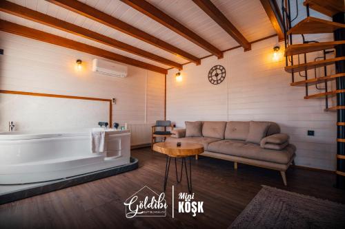 a living room with a couch and a tub and a table at Sapanca Göldibi Suit Bungalov in Sakarya