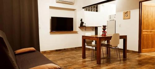 un salon avec une table et une télévision dans l'établissement Appartement charmant près d'Orange avec piscine partagée, à Orange