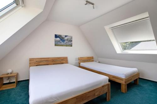 two beds in a small room with a window at Ferienhaus Frida am Deich in Wesselburenerkoog