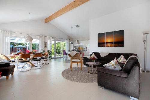 a living room with a couch and a dining room at Ferienhaus Frida am Deich in Wesselburenerkoog