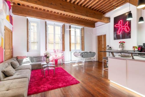 a living room with a couch and a red rug at le XVI de la Rose in Lyon