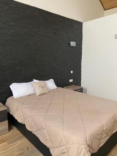 グランドラにあるCasa dos Diogosの黒い壁のベッドルーム1室(大型ベッド1台付)