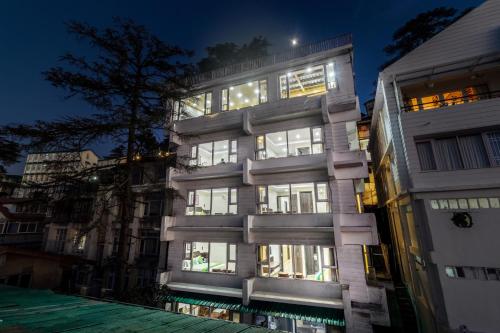 a tall building with many windows at night at Treebo Maharaja, Near Mall Road in Shimla