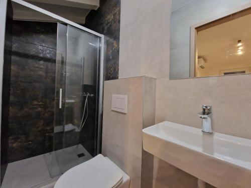 a bathroom with a shower and a toilet and a sink at DAMIAN APARTMENTs in Pula