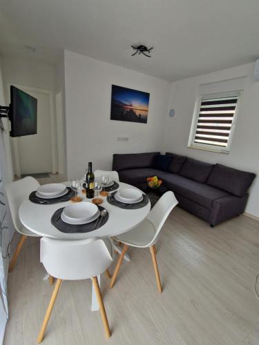 a living room with a table and chairs and a couch at B&L Apartments in Vir