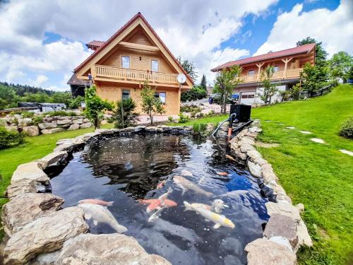 a koi pond in front of a house at Holiday Home Chalet Sven by Interhome in Spiegelau
