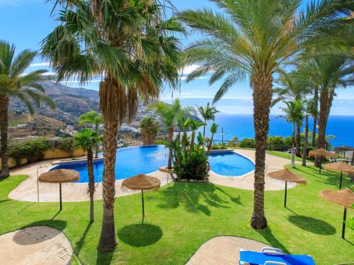 eine Villa mit einem Pool und Palmen in der Unterkunft Apartment Belle Vue by Interhome in Almuñécar