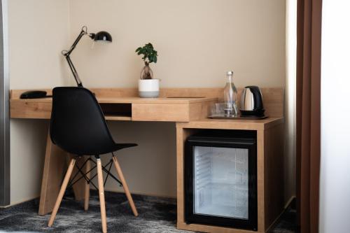 a desk with a black chair and a lamp at Hotel Liberec in Liberec