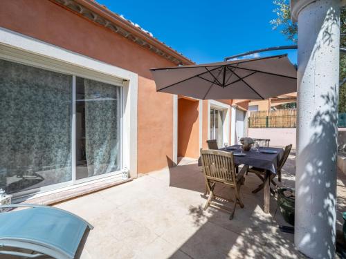a patio with a table and an umbrella at Holiday Home Jasmine by Interhome in Vendres