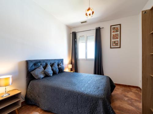 a bedroom with a blue bed and a window at Holiday Home Jasmine by Interhome in Vendres