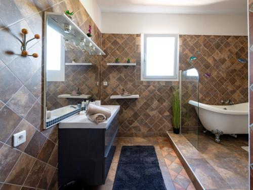 a bathroom with a tub and a sink and a bath tub at Holiday Home Jasmine by Interhome in Vendres
