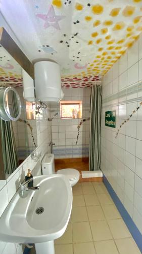 a bathroom with a sink and two toilets and a ceiling with fish on it at Casita Mazo in Mazo