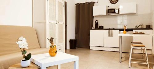 un salon avec une table et une cuisine dans l'établissement Charmant studio près d'Orange - 30 m²! Piscine partagée !, à Orange