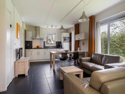 a living room with a couch and a kitchen at Holiday Home Bungalowpark It Wiid by Interhome in Eernewoude