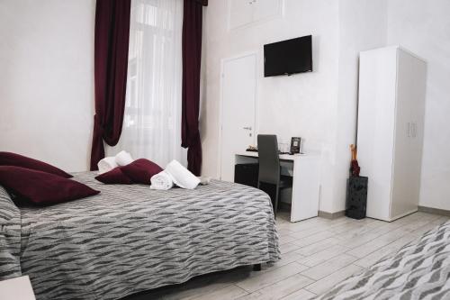 a bedroom with a bed with a desk and a television at 47 Steps in Rome