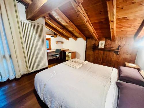 a bedroom with a white bed in a room with wooden ceilings at La Vrille - Metcho in Verrayes