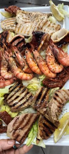 a plate of food with shrimp and lettuce at Hotel Ristorante Antica Marina in Nicotera Marina