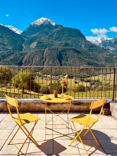 a table and chairs on a balcony with mountains at La Vrille - Metcho in Verrayes