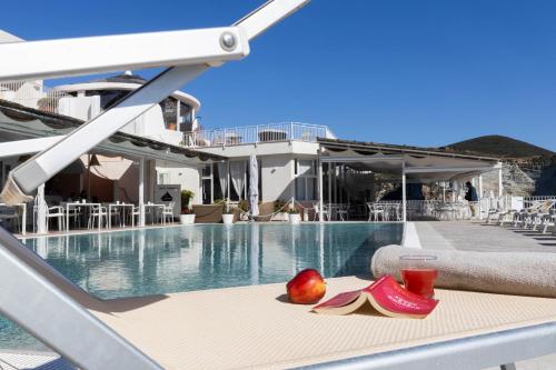 a table with a pair of shoes and a fruit on it at Hotel Chiaia Di Luna in Ponza