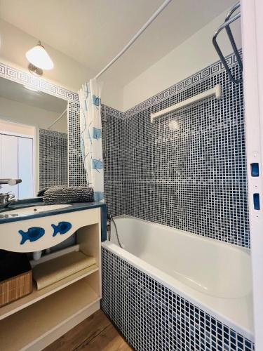 une salle de bain avec une baignoire blanche et un lavabo dans l'établissement Le Baromètre - logement chaleureux, à Talmont-Saint-Hilaire