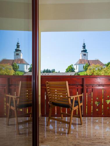 two chairs and a table on a balcony with two lighthouses at Turistična kmetija Pri Marku in Žabnica