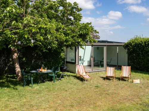 stół i krzesła na podwórku domu w obiekcie Holiday Home Ker Vignan by Interhome w mieście Pleumeur-Bodou