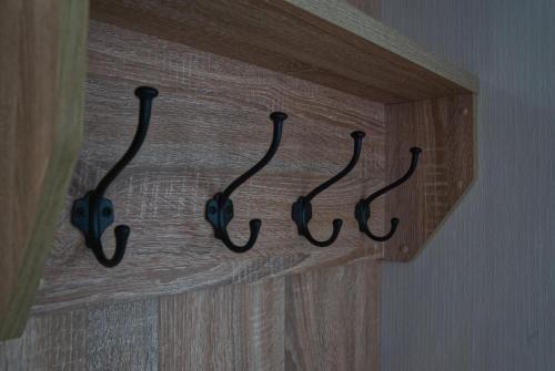 a wooden door with four hooks on a wall at Castle Archdale Holiday Park in Enniskillen