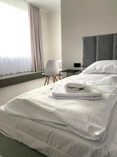 a large white bed with towels on top of it at E-Hotel Łódź in Łódź